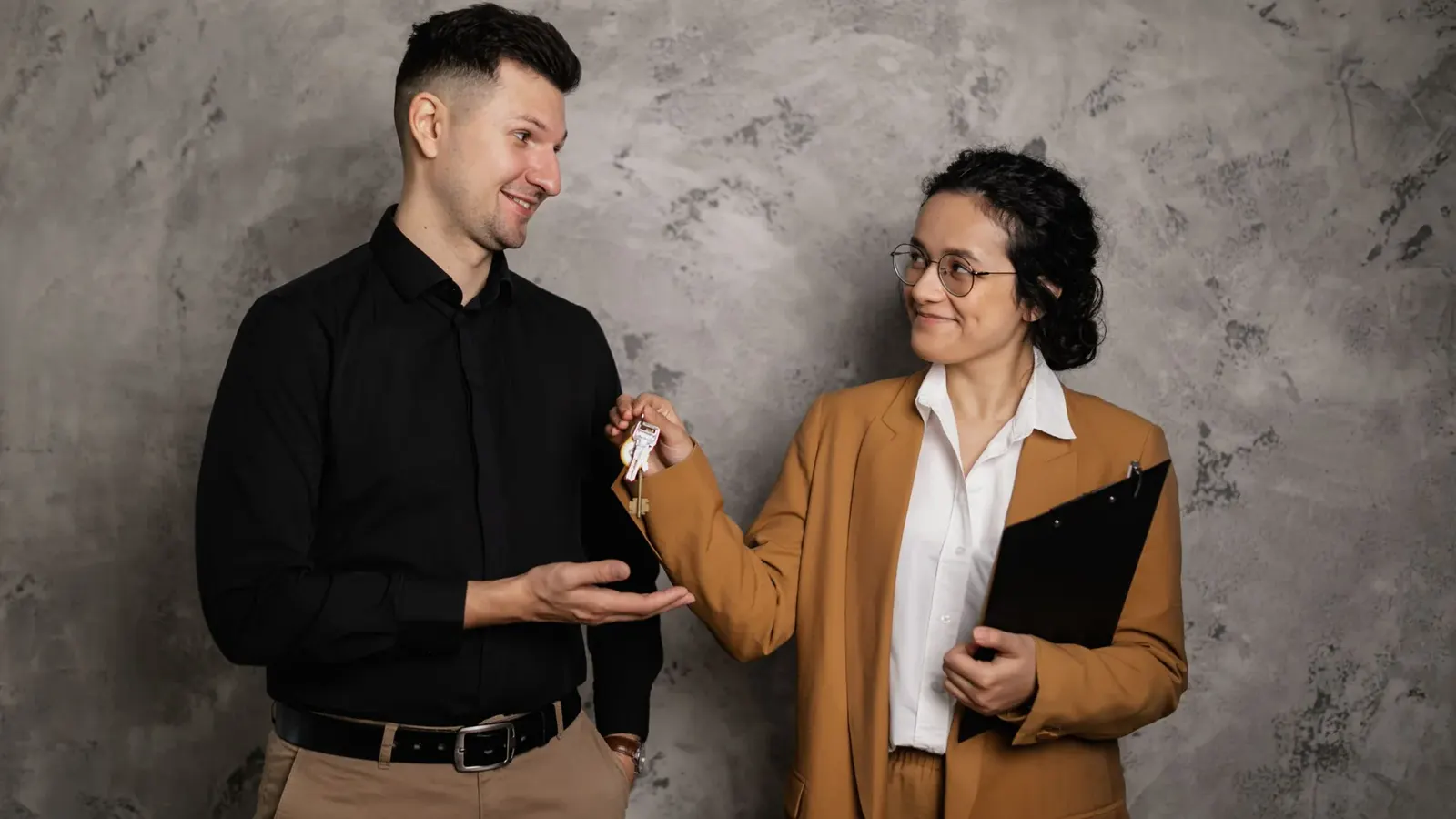 Two people exchanging a set of house keys